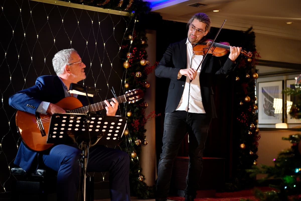 David Garrett spielt Geige beim Traumschiff am 26.12.2022 - hier im Bild mit einem Komparsen, der Gitarre spielt