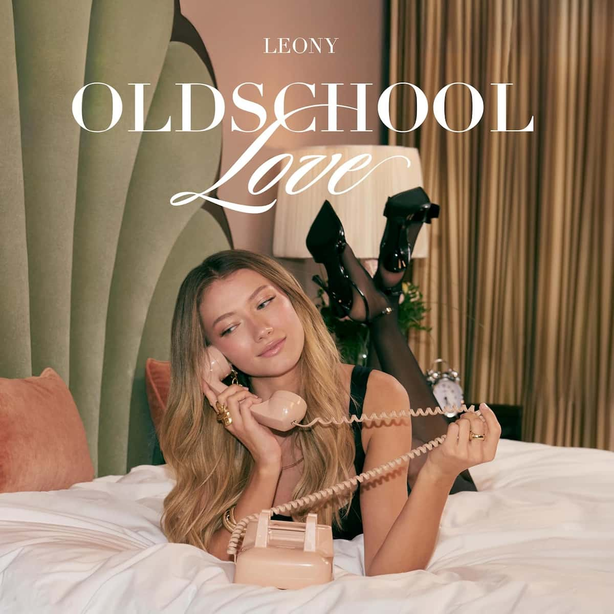 Leony Album Oldschool Love 2025 - hier im Bild das ALbum-Cover mit der Künstlerin, die auf einem Bett liegt und mit einem alten Schnur-Telefon telefoniert